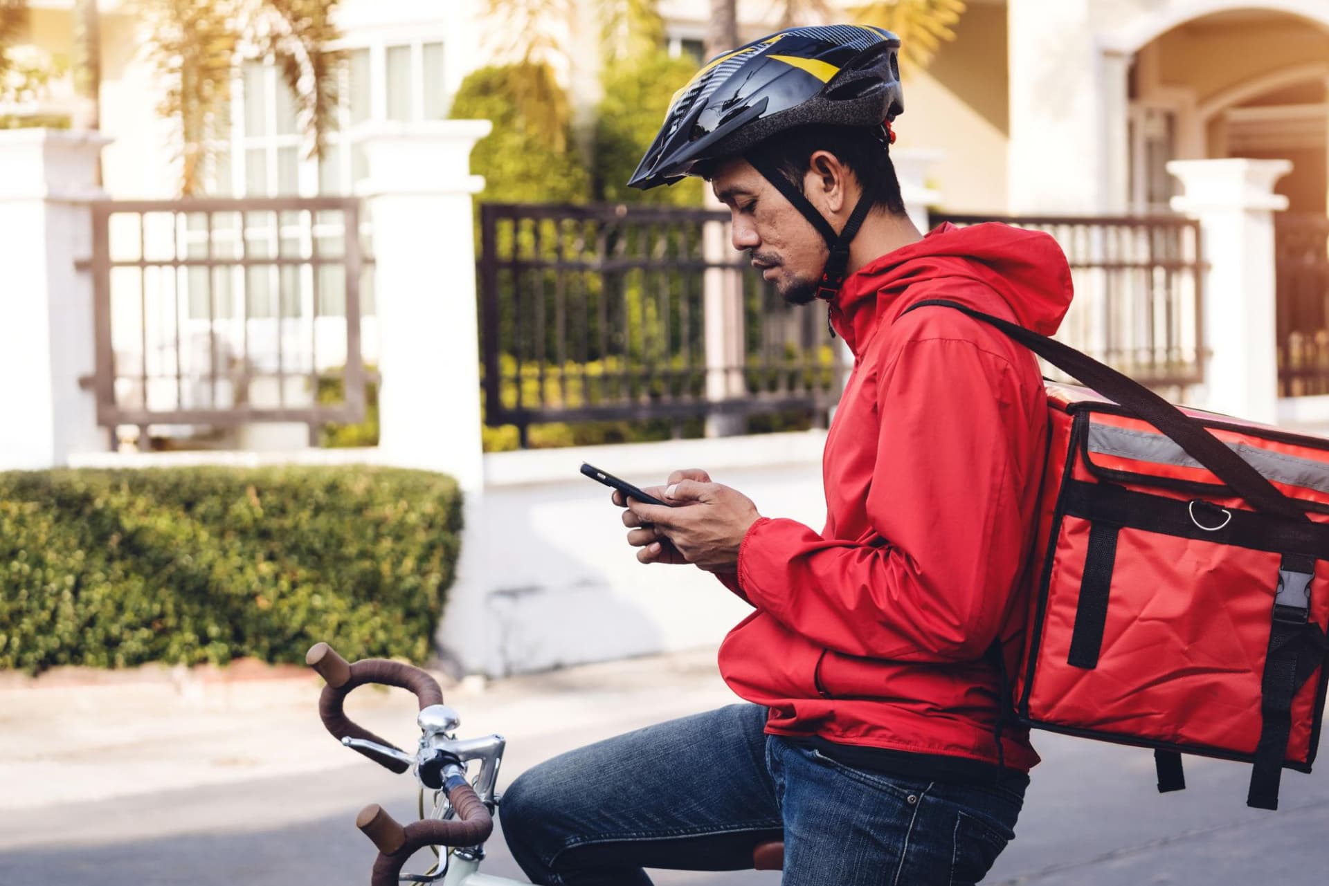Courier riding a bike through the city with a delivery bag